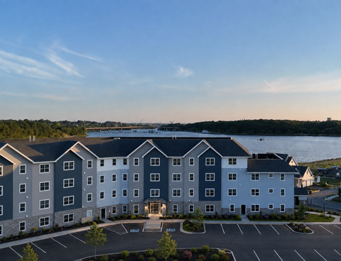A large hotel building with a parking lot in front.