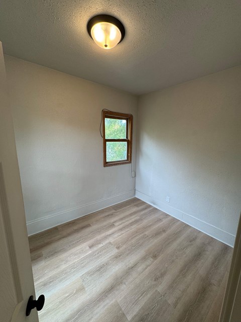 A room with a window and a light on the ceiling.