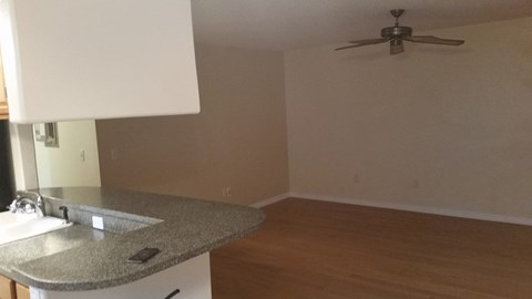 A kitchen with a counter and a fan on the ceiling.