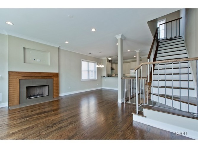 A spacious living room with a fireplace and a staircase.