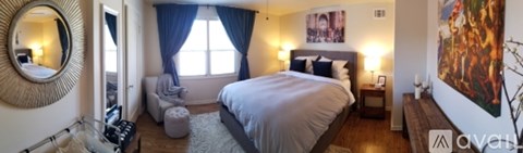 A bedroom with a large bed and a painting on the wall.