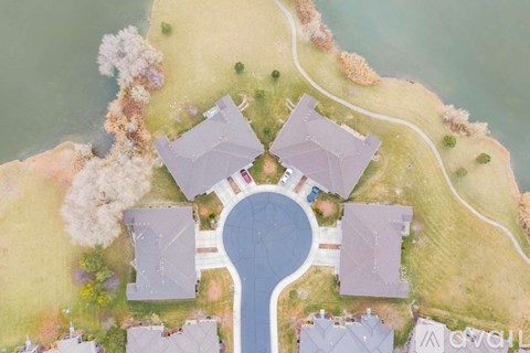 A bird's eye view of a community with houses surrounding a central pool.