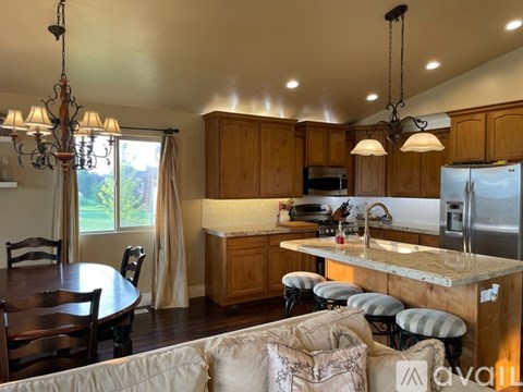 A kitchen with wooden cabinets and a large island with a marble top.