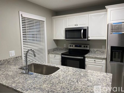 A kitchen with granite countertops and stainless steel appliances.