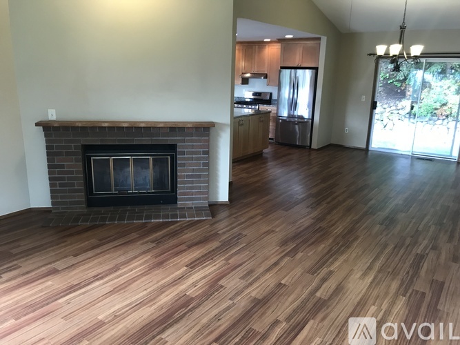 A living room with a fireplace and wooden floors.