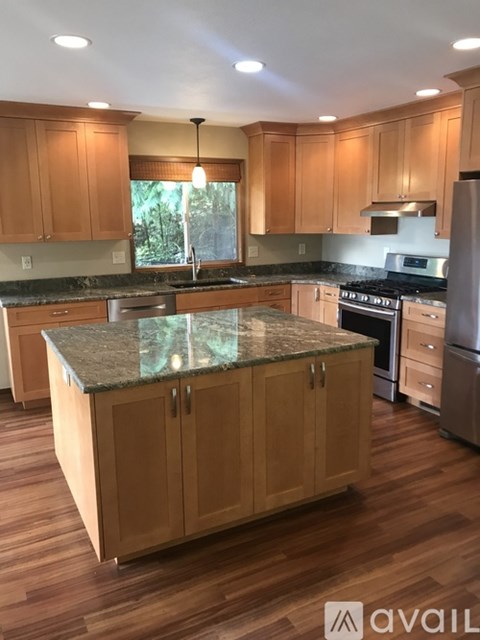 A kitchen with wooden cabinets and a granite countertop.