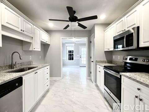 A kitchen with white cabinets and a black stove top oven.