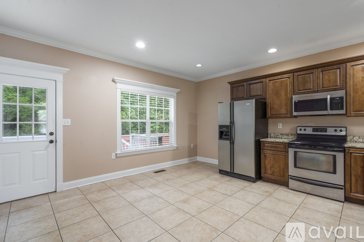 A kitchen with a refrigerator, oven, and microwave.