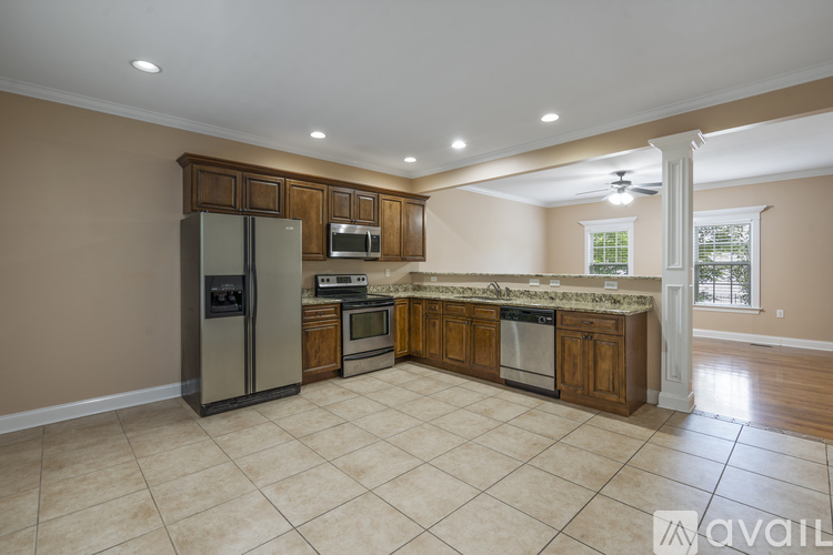 A kitchen with a refrigerator, microwave, oven, and cabinets.