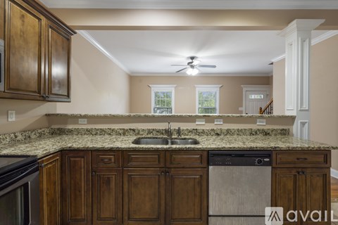 A kitchen with wooden cabinets and a granite countertop.