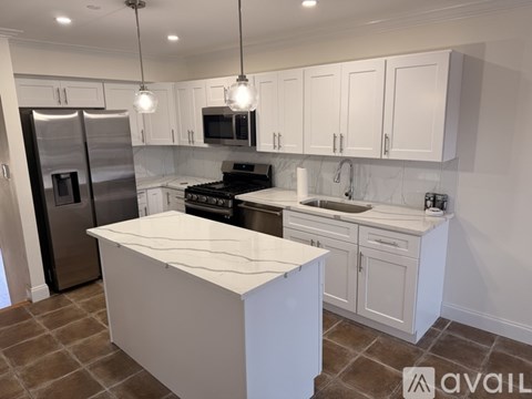 A kitchen with white cabinets and a central island.