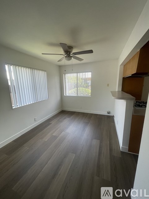 A room with a ceiling fan and wooden flooring.
