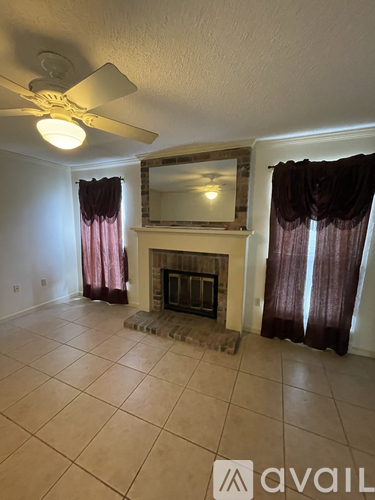 A living room with a fireplace and a fan.