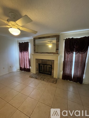 A living room with a fireplace and a fan.