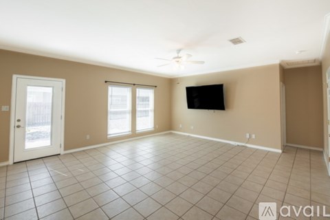 A spacious room with a flat screen TV mounted on the wall and a sliding glass door.