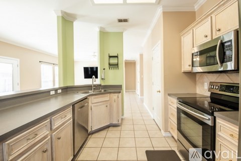 A kitchen with wooden cabinets and black countertops.