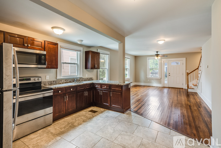 A kitchen with wooden cabinets and a stainless steel refrigerator.