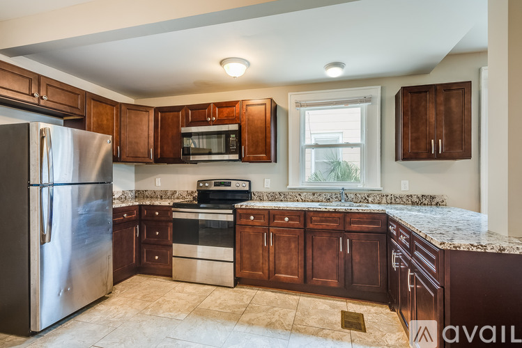 A kitchen with brown cabinets and a stainless steel refrigerator.