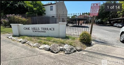 A sign for Oak Hills Terrace is displayed in front of a gated entrance.