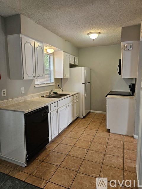 A kitchen with white cabinets and a black dishwasher.