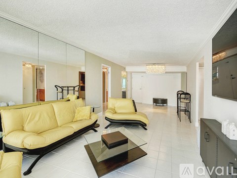 A living room with a yellow sofa and a coffee table.