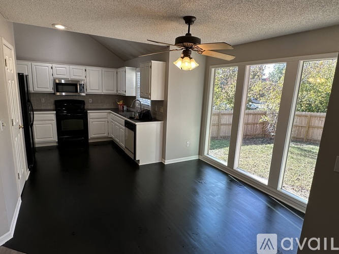 A kitchen with black floors and white cabinets.