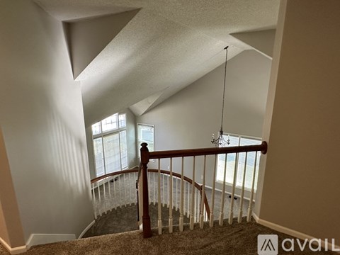A staircase with a carpeted runner and a wooden handrail.
