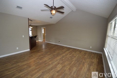 A room with wooden floors and a ceiling fan.