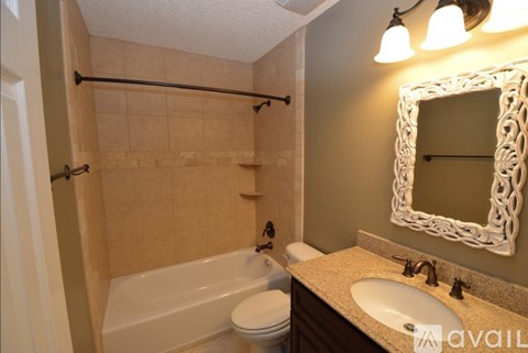 A bathroom with a white tub, toilet, and sink.