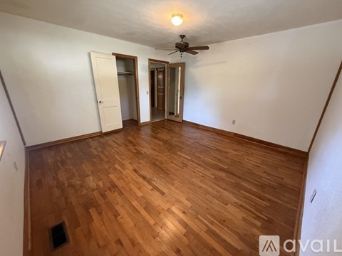 A bedroom with a bed, a ceiling fan, and a digital clock showing 4:10 PM.