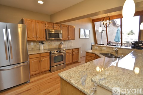 A kitchen with wooden cabinets and granite countertops.