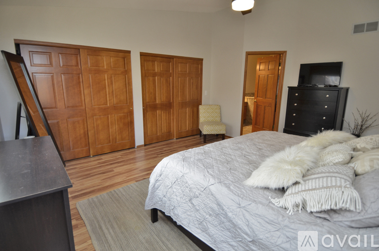 A bedroom with a large bed and wooden doors.