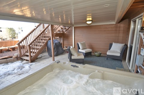 A hot tub is in the middle of a wooden deck.