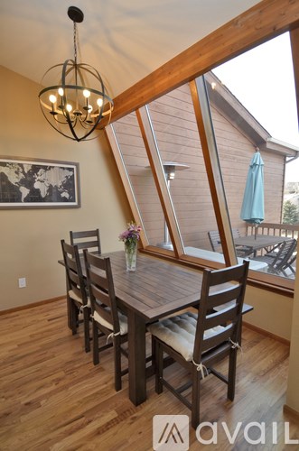 A dining room with a wooden table and chairs.
