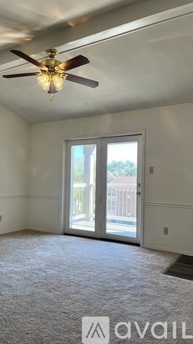 A room with a ceiling fan and a door leading outside.