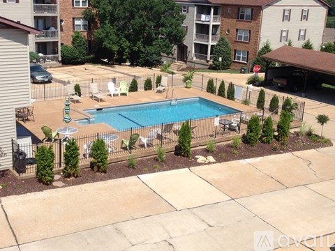 A small pool surrounded by a fence and trees.