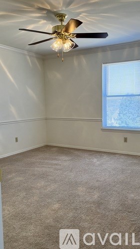 A room with a ceiling fan and carpeted floor.