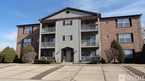 A two-story apartment building with a parking lot in front.