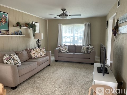 A living room with two grey couches and a television.