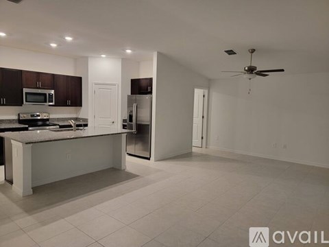 A kitchen with a white island and a ceiling fan.