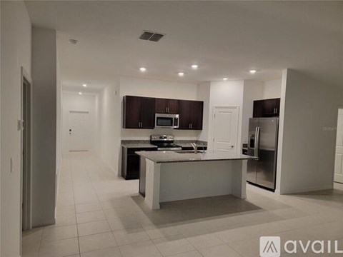 A modern kitchen with a central island and stainless steel appliances.