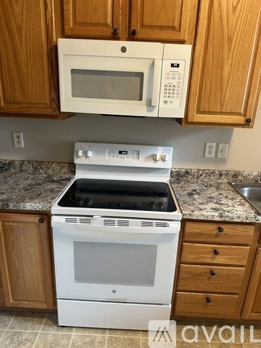 A white oven and microwave are installed in a kitchen.