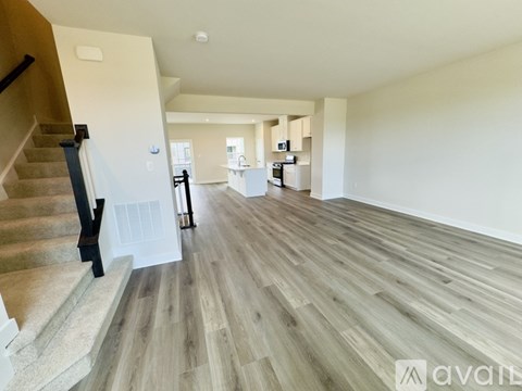 A spacious living room with a staircase on the left side.