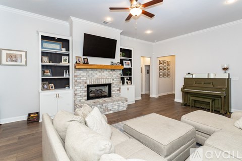 A living room with a fireplace and a television on the wall.
