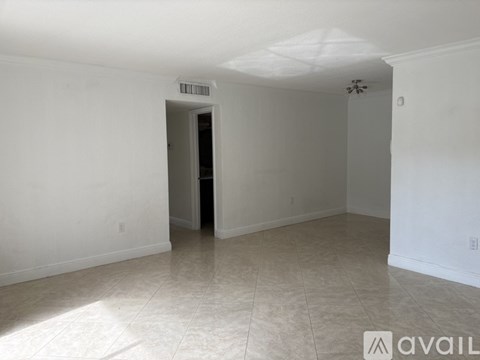 A room with a tiled floor and a doorway leading to another room.
