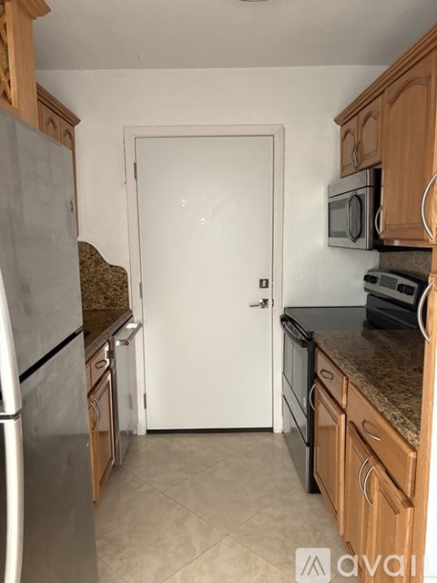 A kitchen with a white door in the middle.