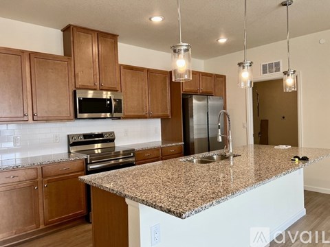 A kitchen with granite countertops and wooden cabinets.