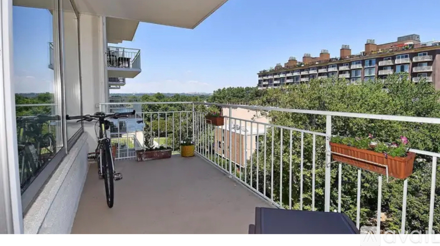 A balcony with a bicycle and a table with a plant on it.
