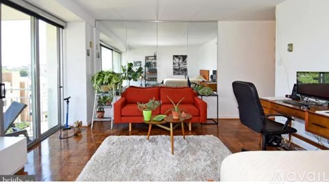 A living room with a red couch and a white chair.