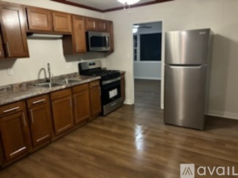 A kitchen with wooden cabinets and a stainless steel refrigerator.